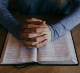 Photo by Patrick Fore man holding his hands on open book